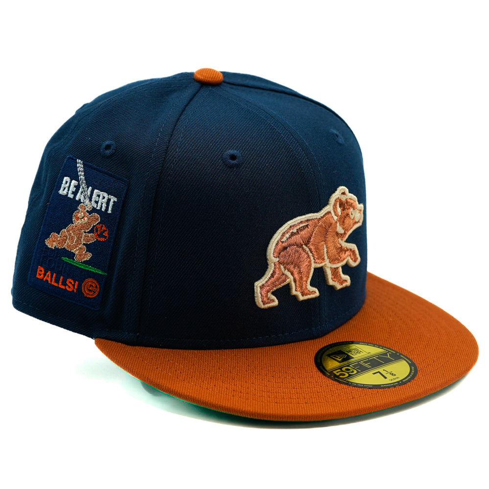 Navy and orange Chicago cubs cap with bear design and patch on a white background